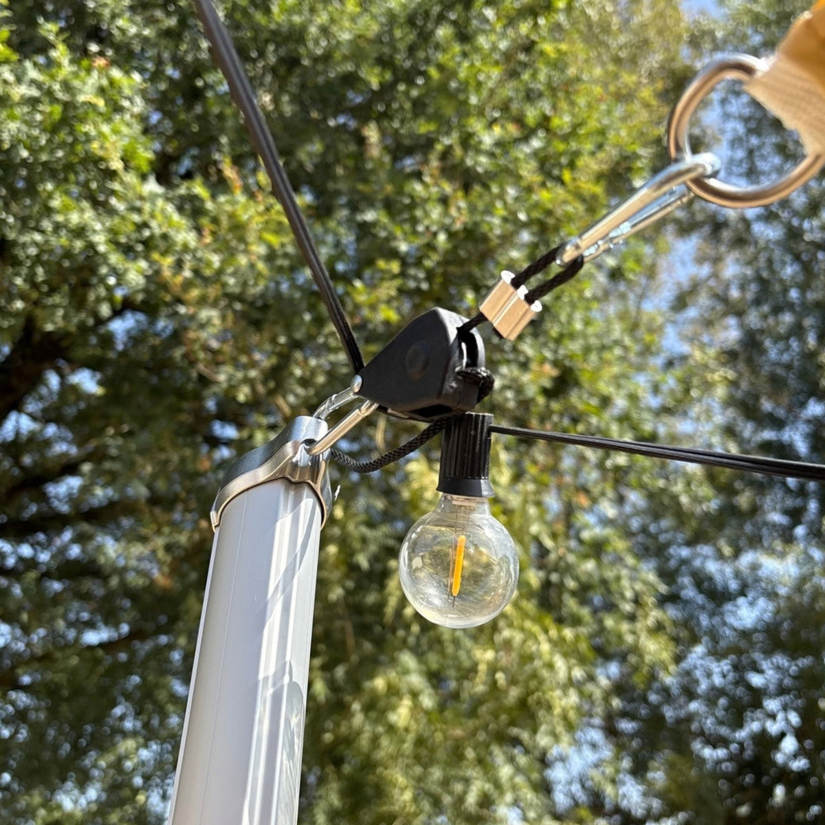 Tensor de cuerda con polea instalado en un mástil con guirnalda luminosa