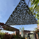 Red de camuflaje triangular oscura sobre una pérgola de jardín
